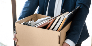 person leaving office with box of belongings